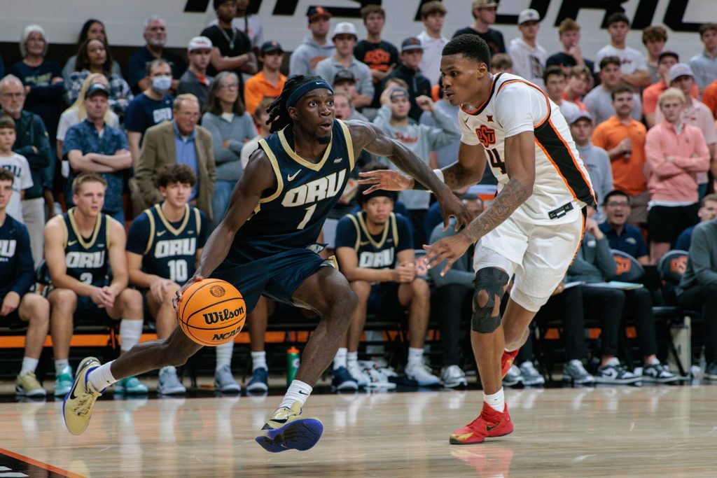 Nov 4, 2025; Stillwater, Oklahoma, USA; Oral Roberts Golden Eagles guard Ty Harper (1) drives to the basket around Oklahoma State Cowboys forward Christian Coleman (4) during the second half at Gallagher-Iba Arena. Mandatory Credit: William Purnell-Imagn Images