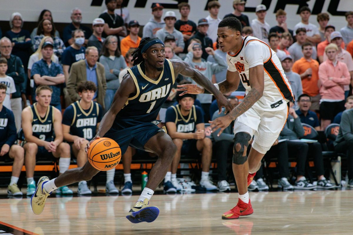 Nov 4, 2025; Stillwater, Oklahoma, USA; Oral Roberts Golden Eagles guard Ty Harper (1) drives to the basket around Oklahoma State Cowboys forward Christian Coleman (4) during the second half at Gallagher-Iba Arena. Mandatory Credit: William Purnell-Imagn Images