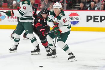 Nov 6, 2025; Raleigh, North Carolina, USA;  Minnesota Wild left wing Kirill Kaprizov (97) skates wwsith the puck inside of Carolina Hurricanes center Jordan Staal (11) during the first period at Lenovo Center. Mandatory Credit: James Guillory-Imagn Images