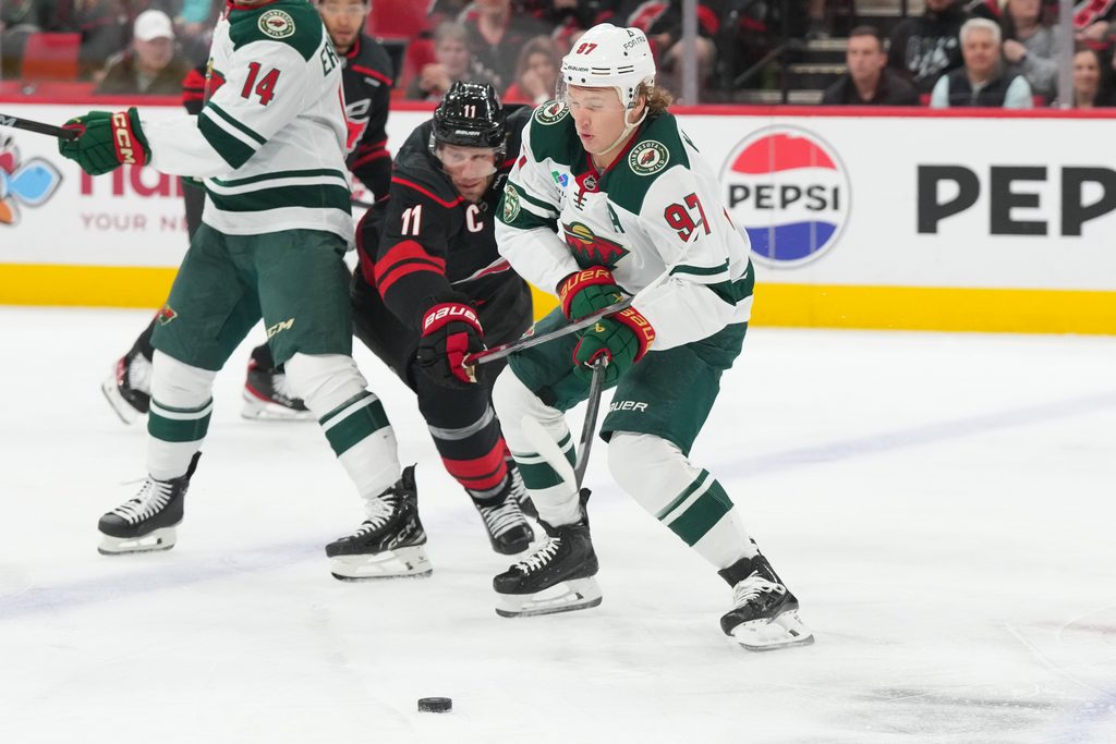 Nov 6, 2025; Raleigh, North Carolina, USA; Minnesota Wild left wing Kirill Kaprizov (97) skates wwsith the puck inside of Carolina Hurricanes center Jordan Staal (11) during the first period at Lenovo Center. Mandatory Credit: James Guillory-Imagn Images
