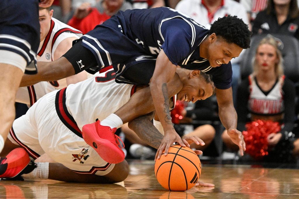 Nov 6, 2025; Louisville, Kentucky, USA; Jackson State Tigers guard Daeshun Ruffin (24) scrambles for the ball with Louisville Cardinals forward Khani Rooths (9) during the second half at KFC Yum! Center. Louisville defeated Jackson State 106-70. Mandatory Credit: Jamie Rhodes-Imagn Images