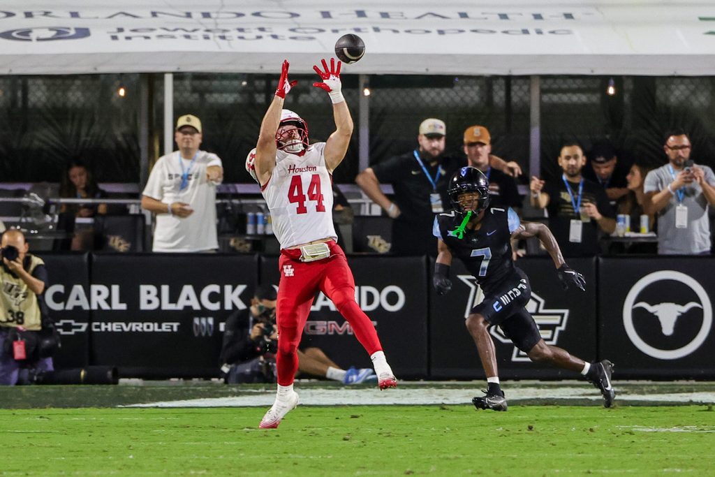 Nov 7, 2025; Orlando, Florida, USA; Houston Cougars running back Dean Connors (44) catches a pass in front of UCF Knights defensive back Antione Jackson (7) during the second half at Acrisure Bounce House. Mandatory Credit: Mike Watters-Imagn Images
