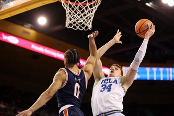 Nov 7, 2025; Los Angeles, California, USA;  UCLA Bruins forward Tyler Bilodeau (34) goes to the basket against Pepperdine Waves guard Styles Phipps (0) during the second half at Pauley Pavilion presented by Wescom Financial. Mandatory Credit: Kiyoshi Mio-Imagn Images