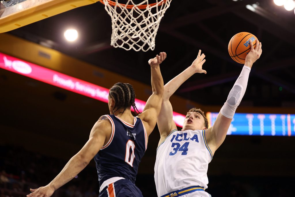 Nov 7, 2025; Los Angeles, California, USA; UCLA Bruins forward Tyler Bilodeau (34) goes to the basket against Pepperdine Waves guard Styles Phipps (0) during the second half at Pauley Pavilion presented by Wescom Financial. Mandatory Credit: Kiyoshi Mio-Imagn Images