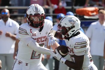 Nov 8, 2025; Lubbock, Texas, USA;  Texas Tech Red Raiders quarterback Behren Morton (2) hands the ball to running back J’Koby Williams (20) in the first half Brigham Young Cougars at Jones AT&T Stadium. Mandatory Credit: Michael C. Johnson-Imagn Images
