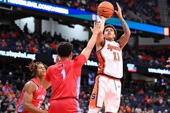 Nov 8, 2025; Syracuse, New York, USA; Syracuse Orange guard Naithan George (11) shoots the ball over Delaware State Hornets guard Ponce James (1) and guard John Clemmons (5) in the second half at the JMA Wireless Dome. Mandatory Credit: Mark Konezny-Imagn Images