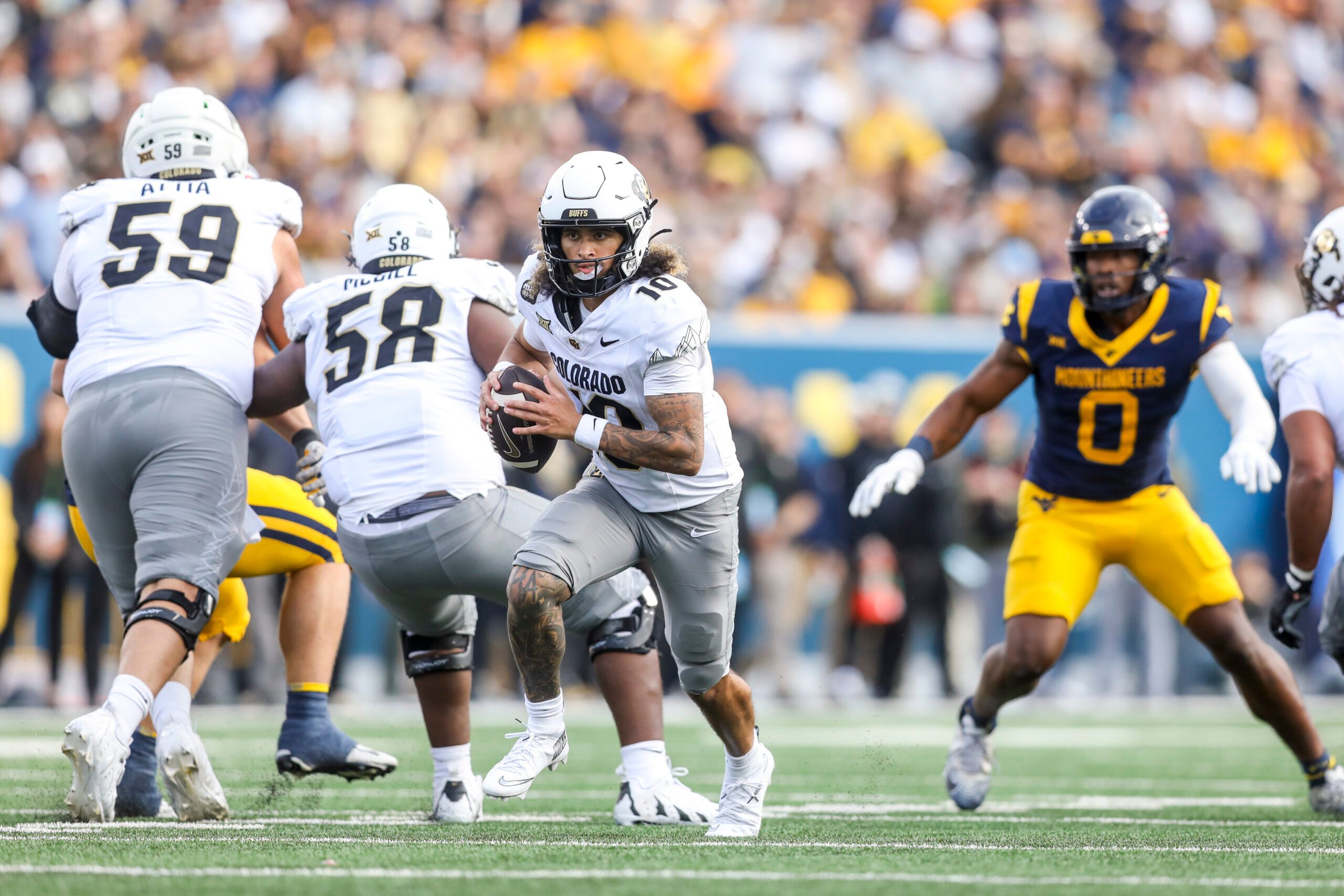 Nov 8, 2025; Morgantown, West Virginia, USA; Colorado Buffaloes quarterback Julian Lewis (10) runs out of the pocket during the third quarter against the West Virginia Mountaineers at Milan Puskar Stadium. Mandatory Credit: Ben Queen-Imagn Images