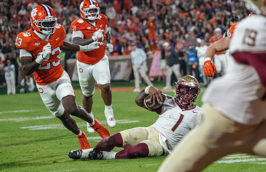 Nov 8, 2025; Clemson, South Carolina, USA; Florida State Seminoles quarterback Tommy Castellanos (1) slides near Clemson Tigers cornerback Ashton Hampton (23) during the second quarter at Memorial Stadium. Mandatory Credit: Ken Ruinard - GREENVILLE NEWS-USA TODAY Network via Imagn Images