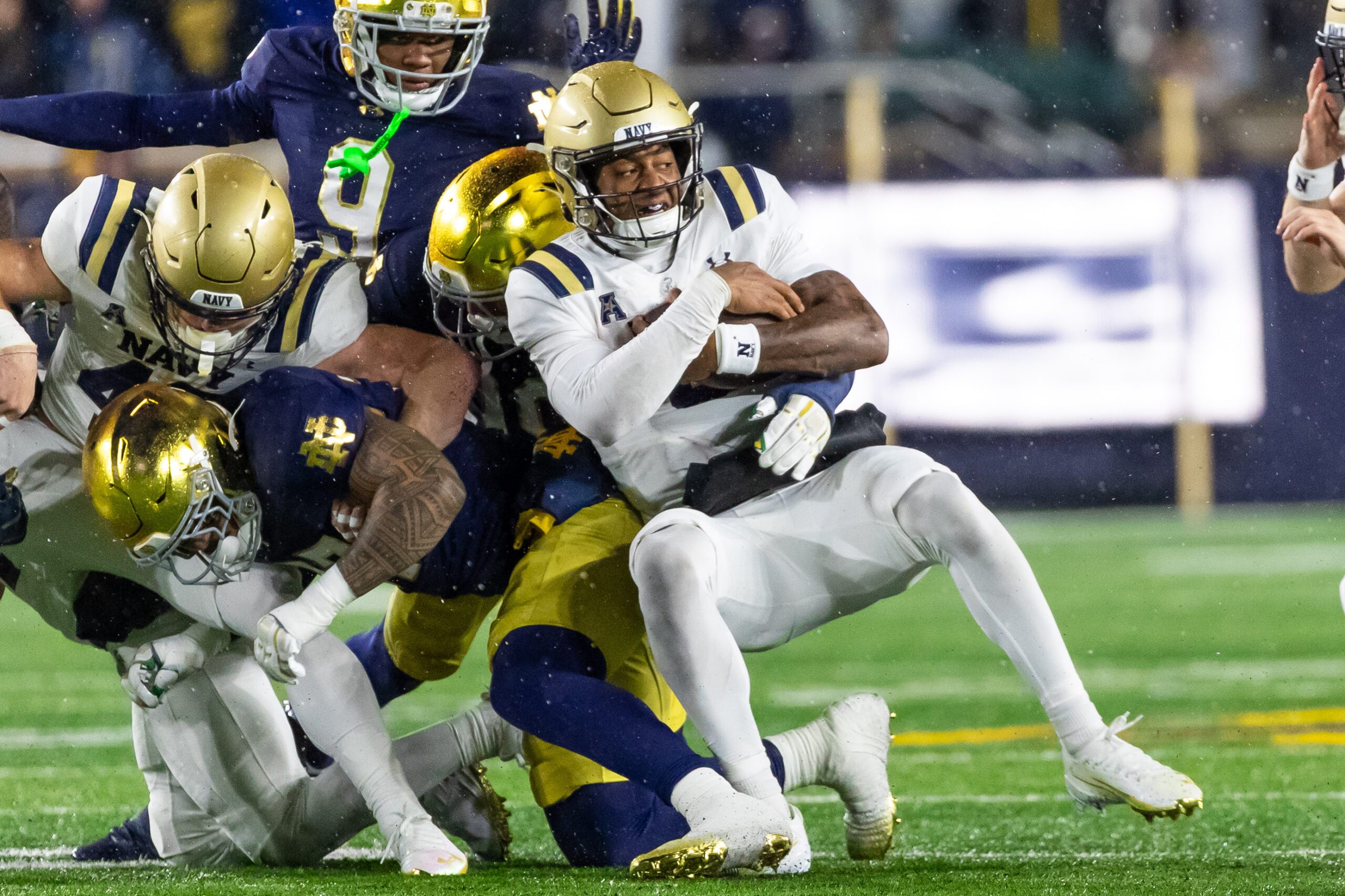 Nov 8, 2025; South Bend, Indiana, USA; Navy Midshipmen quarterback Braxton Woodson (5) gets stopped by the Notre Dame Fighting Irish defense during the second half at Notre Dame Stadium. Mandatory Credit: Michael Caterina-Imagn Images