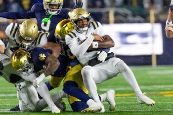 Nov 8, 2025; South Bend, Indiana, USA; Navy Midshipmen quarterback Braxton Woodson (5) gets stopped by the Notre Dame Fighting Irish defense during the second half at Notre Dame Stadium. Mandatory Credit: Michael Caterina-Imagn Images