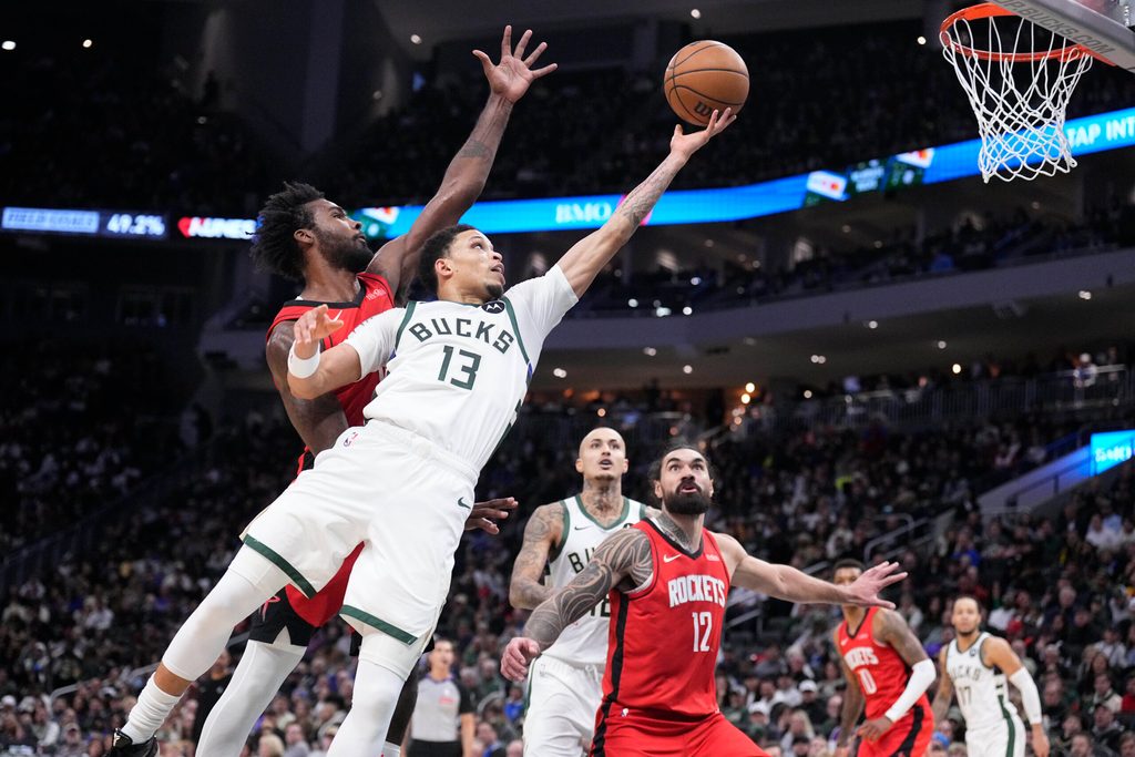 Nov 9, 2025; Milwaukee, Wisconsin, USA; Milwaukee Bucks guard Ryan Rollins (13) lays up a shot against Houston Rockets forward Tari Eason (17) in the second half at Fiserv Forum. Mandatory Credit: Michael McLoone-Imagn Images