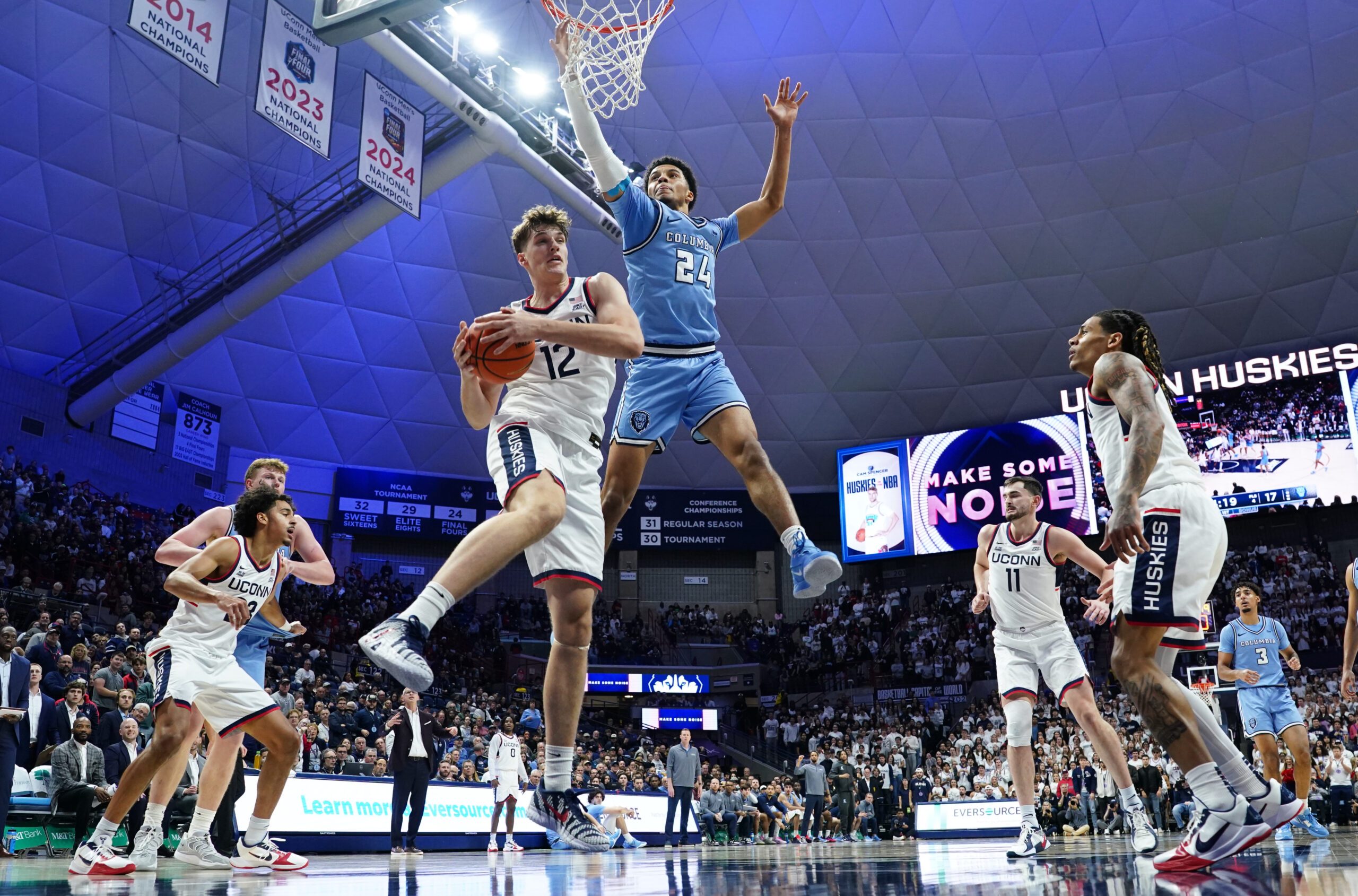 Nov 10, 2025; Storrs, Connecticut, USA; UConn Huskies center Eric Reibe (12) grabs the rebound against Columbia Lions guard Miles Franklin (24) in the first half at Harry A. Gampel Pavilion. Mandatory Credit: David Butler II-Imagn Images
