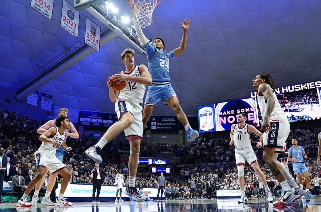 Nov 10, 2025; Storrs, Connecticut, USA; UConn Huskies center Eric Reibe (12) grabs the rebound against Columbia Lions guard Miles Franklin (24) in the first half at Harry A. Gampel Pavilion. Mandatory Credit: David Butler II-Imagn Images
