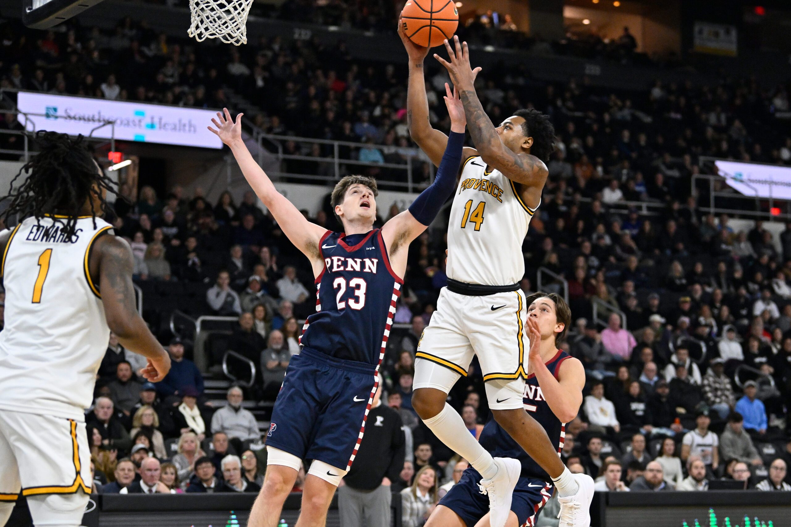 Nov 11, 2025; Providence, Rhode Island, USA; Providence Friars guard Jr. Corey Floyd (14) shoots a layup against Penn Quakers forward Ethan Roberts (23) during the first half at Amica Mutual Pavilion. Mandatory Credit: Eric Canha-Imagn Images