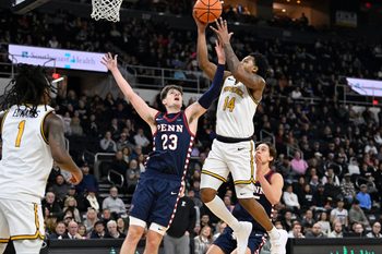 Nov 11, 2025; Providence, Rhode Island, USA; Providence Friars guard Jr. Corey Floyd (14) shoots a layup against Penn Quakers forward Ethan Roberts (23) during the first half at Amica Mutual Pavilion. Mandatory Credit: Eric Canha-Imagn Images