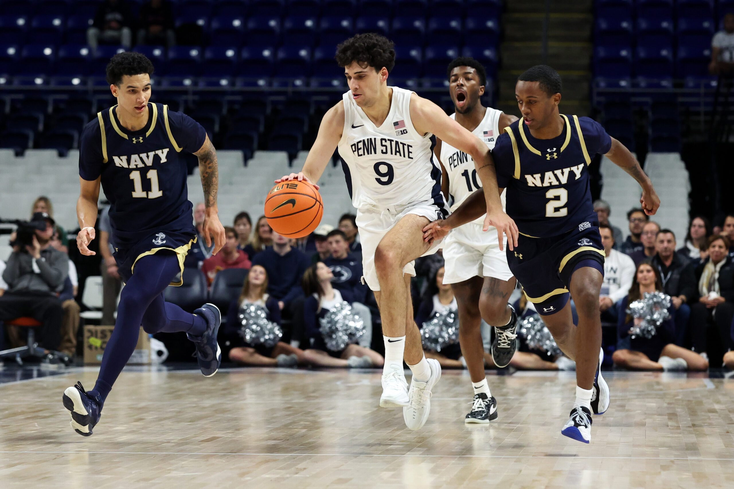 Nov 11, 2025; University Park, Pennsylvania, USA; Penn State Nittany Lions guard Melih Tunca (9) dribbles the ball up the court as Navy Midshipmen forward Donovan Draper (11) and guard Cam Cole (2) defend during the first half at Bryce Jordan Center. Mandatory Credit: Matthew O'Haren-Imagn Images