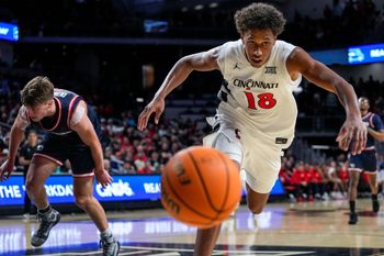 Cincinnati Bearcats forward Baba Miller (18) chases a loose ball out of bounds in the second half of the NCAA Men’s Basketball game between the Cincinnati Bearcats and the Dayton Flyers at Fifth Third Arena in Cincinnati on Tuesday, Nov. 11, 2025. The Bearcats won 74-62.