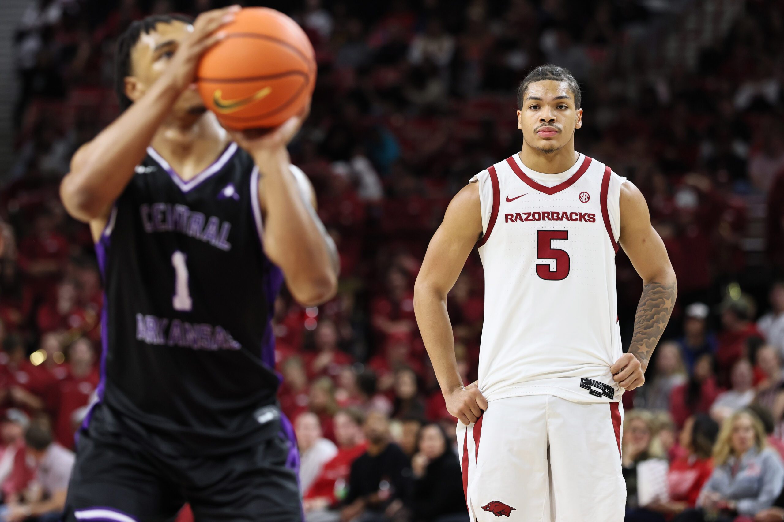 Nov 11, 2025; Fayetteville, Arkansas, USA; Arkansas Razorbacks guard Darius Acuff Jr. (5) looks on as UCA Bears guard Camren Hunter (1) shoots a free throw in the second half at Bud Walton Arena. Arkansas won 93-56. Mandatory Credit: Nelson Chenault-Imagn Images