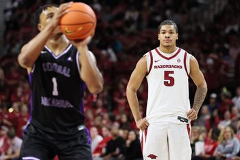 Nov 11, 2025; Fayetteville, Arkansas, USA; Arkansas Razorbacks guard Darius Acuff Jr. (5) looks on as UCA Bears guard Camren Hunter (1) shoots a free throw in the second half at Bud Walton Arena. Arkansas won 93-56. Mandatory Credit: Nelson Chenault-Imagn Images