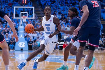 Nov 11, 2025; Chapel Hill, North Carolina, USA; North Carolina Tar Heels forward Caleb Wilson (8) drives past Radford Highlanders guard Jr. Dennis Parker (11) during the second half at Dean E. Smith Center. Mandatory Credit: Scott Kinser-Imagn Images