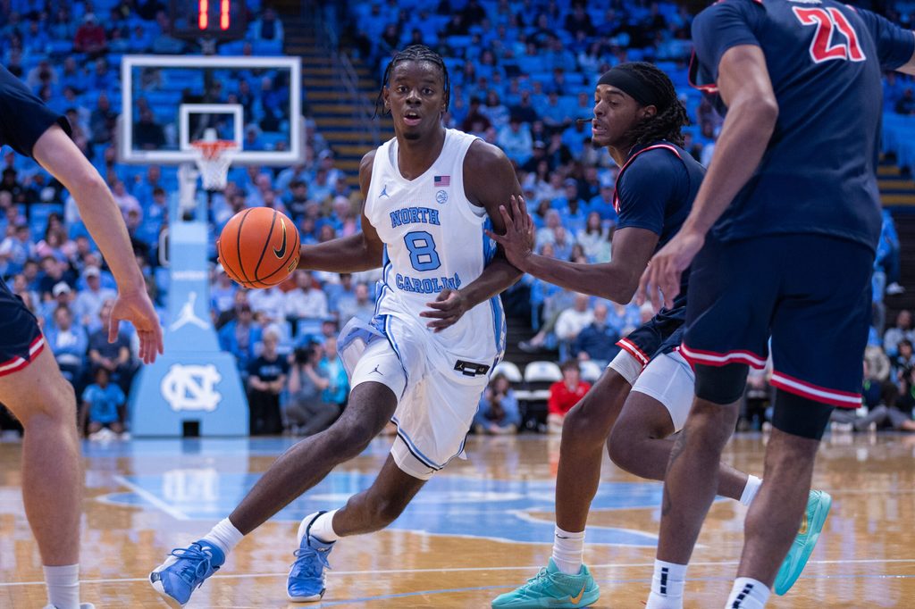 Nov 11, 2025; Chapel Hill, North Carolina, USA; North Carolina Tar Heels forward Caleb Wilson (8) drives past Radford Highlanders guard Jr. Dennis Parker (11) during the second half at Dean E. Smith Center. Mandatory Credit: Scott Kinser-Imagn Images