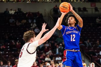 Nov 12, 2025; Columbia, South Carolina, USA; Presbyterian Blue Hose guard Carl Parrish (12) shoots over South Carolina Gamecocks guard Eli Ellis (15) in the second half at Colonial Life Arena. Mandatory Credit: Jeff Blake-Imagn Images