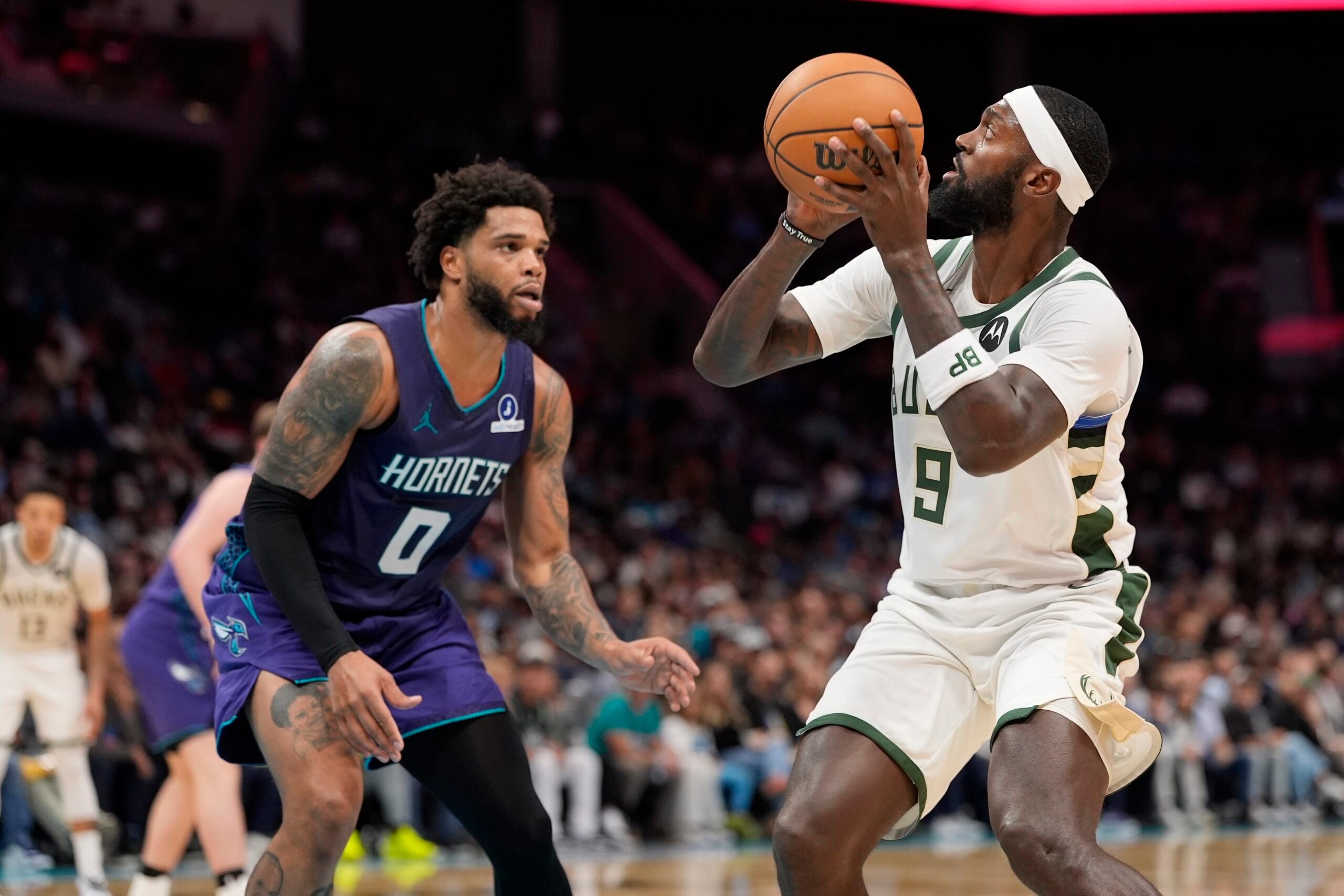 Nov 12, 2025; Charlotte, North Carolina, USA; Milwaukee Bucks forward Bobby Portis (9) shoots the ball defended by Charlotte Hornets forward Miles Bridges (0) during the second half at Spectrum Center. Mandatory Credit: Jim Dedmon-Imagn Images