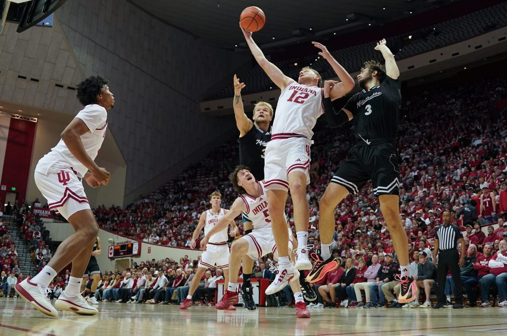 Nov 12, 2025; Bloomington, Indiana, USA; Indiana Hoosiers forward Tucker Devries (12) rebounds the ball against Milwaukee Panthers forward Danilo Jovanovich (3) during the second half at Simon Skjodt Assembly Hall. Mandatory Credit: Robert Goddin-Imagn Images