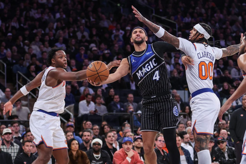 Nov 12, 2025; New York, New York, USA; Orlando Magic guard Jalen Suggs (4) drives past New York Knicks forward OG Anunoby (8) and guard Jordan Clarkson (00) in the fourth quarter at Madison Square Garden. Mandatory Credit: Wendell Cruz-Imagn Images