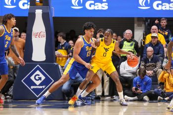 Nov 13, 2025; Morgantown, West Virginia, USA; West Virginia Mountaineers forward Brenen Lorient (0) dribbles against Pittsburgh Panthers forward Roman Siulepa (13) during the first half at WVU Coliseum. Mandatory Credit: Ben Queen-Imagn Images