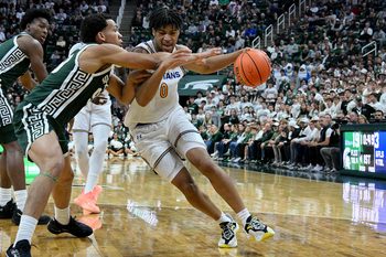 Nov 13, 2025; East Lansing, Michigan, USA;  San Jose State Spartans guard Colby Garland (0) dribbles against Michigan State Spartans guard Divine Ugochukwu (99) during the first half at Jack Breslin Student Events Center. Mandatory Credit: Dale Young-Imagn Images
