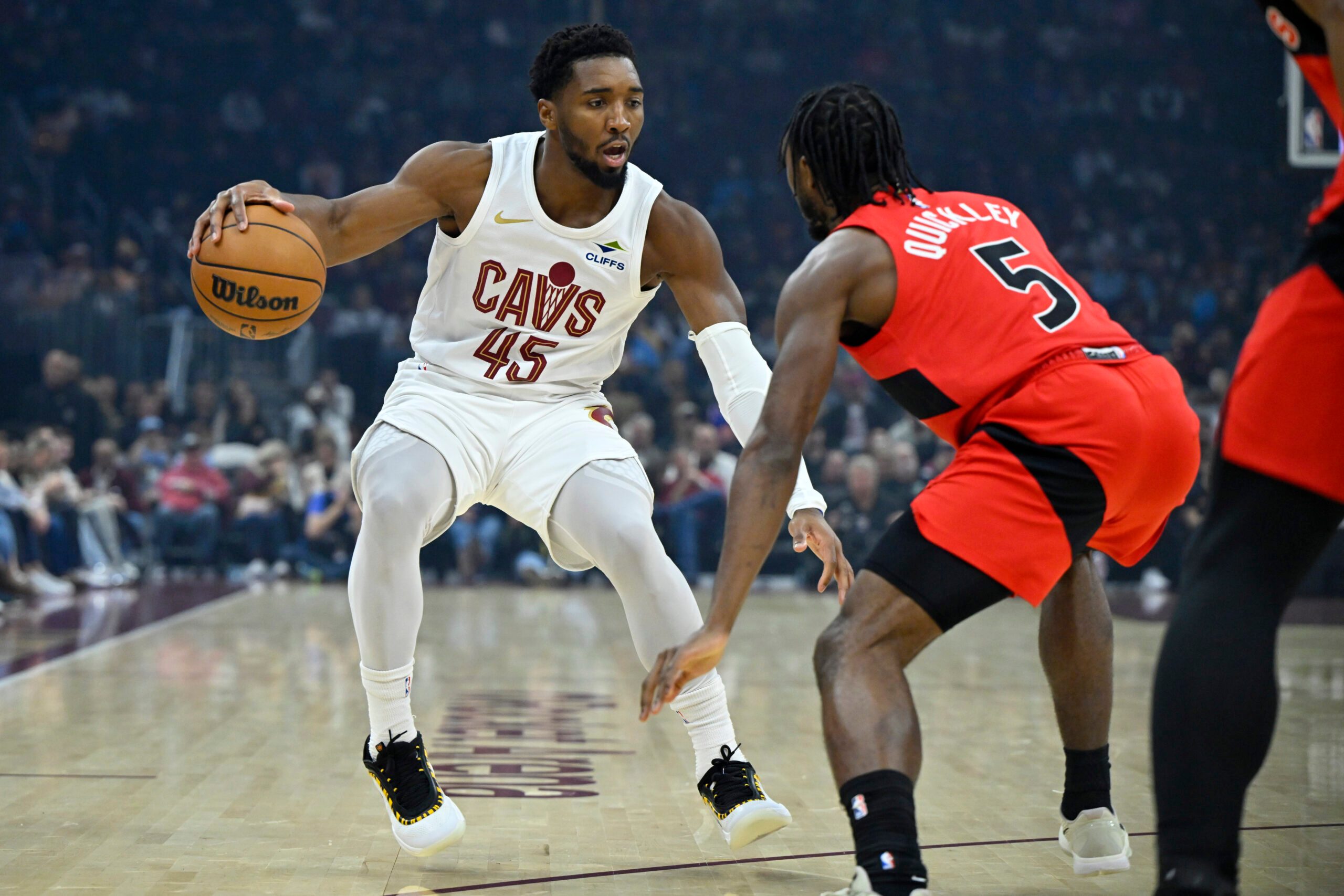 Nov 13, 2025; Cleveland, Ohio, USA; Cleveland Cavaliers guard Donovan Mitchell (45) dribbles beside Toronto Raptors guard Immanuel Quickley (5) in the first quarter at Rocket Arena. Mandatory Credit: David Richard-Imagn Images