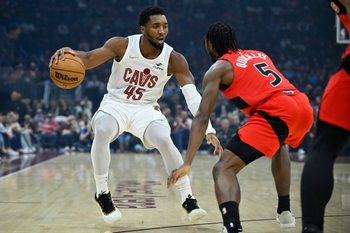 Nov 13, 2025; Cleveland, Ohio, USA; Cleveland Cavaliers guard Donovan Mitchell (45) dribbles beside Toronto Raptors guard Immanuel Quickley (5) in the first quarter at Rocket Arena. Mandatory Credit: David Richard-Imagn Images