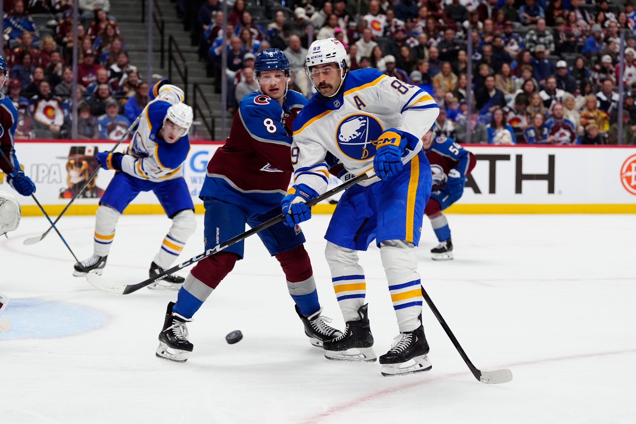 Nov 13, 2025; Denver, Colorado, USA; Buffalo Sabres right wing Alex Tuch (89) and Colorado Avalanche defenseman Cale Makar (8) battle for the puck in the third period at Ball Arena. Mandatory Credit: Ron Chenoy-Imagn Images