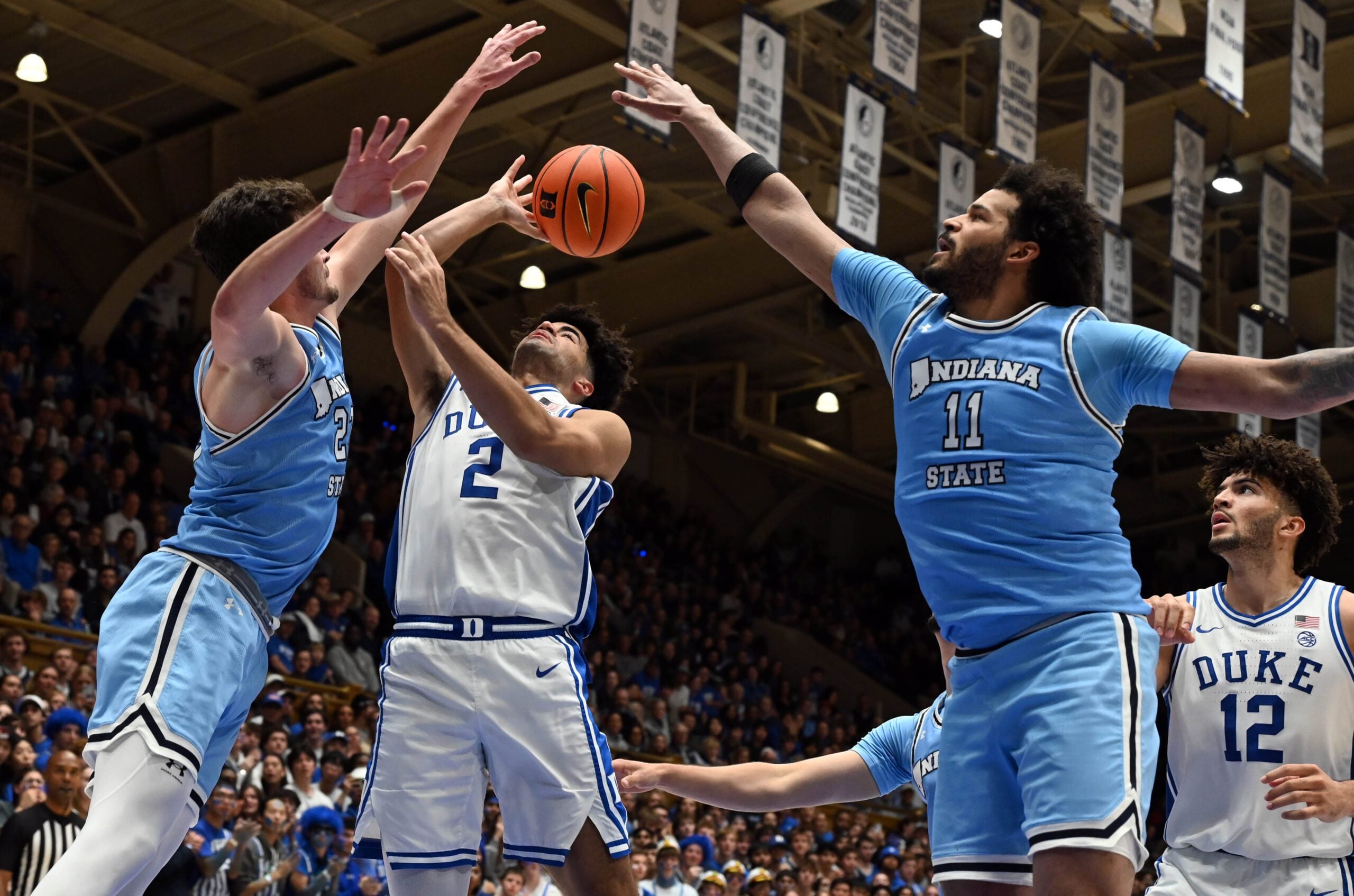 Nov 14, 2025; Durham, North Carolina, USA;  Duke Blue Devils guard Cayden Boozer (2) throws a pass in front of Indiana State Sycamores forward Ian Scott (23) and center Markus Harding (11) during the second half at Cameron Indoor Stadium. Mandatory Credit: Rob Kinnan-Imagn Images