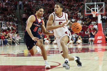 Nov 14, 2025; Fayetteville, Arkansas, USA; Arkansas Razorbacks guard Darius Acuff Jr (5) drives against Samford Bulldogs guard Isaiah Campbell-Finch (0) during the second half at Bud Walton Arena. Arkansas won 79-75. Mandatory Credit: Nelson Chenault-Imagn Images
