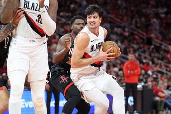 Nov 14, 2025; Houston, Texas, USA;  Portland Trail Blazers forward Deni Avdija (8) controls the ball as Houston Rockets guard Aaron Holiday (0) defends during the third quarter at Toyota Center. Mandatory Credit: Troy Taormina-Imagn Images