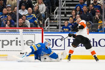 Nov 14, 2025; St. Louis, Missouri, USA; St. Louis Blues goaltender Jordan Binnington (50) makes a save against Philadelphia Flyers defenseman Jamie Drysdale (9) during overtime at Enterprise Center. Mandatory Credit: Jeff Curry-Imagn Images