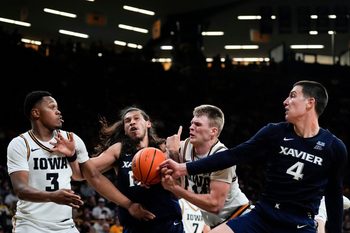 Iowa forward Cam Manyawu (3), Xavier forward Tre Carroll (12), Iowa guard Bennett Stirtz (14) and Xavier forward Filip Borovicanin (4) reach for a rebound Nov. 14, 2025 at Carver-Hawkeye Arena in Iowa City, Iowa.