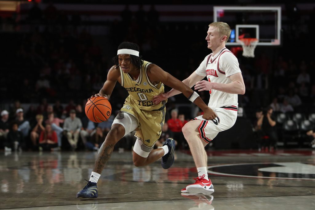 Nov 14, 2025; Athens, Georgia, USA; Georgia Tech Yellow Jackets guard Akai Fleming (0) dribbles past Georgia Bulldogs guard Blue Cain (0) during the second half at Stegeman Coliseum. Mandatory Credit: Mady Mertens-Imagn Images
