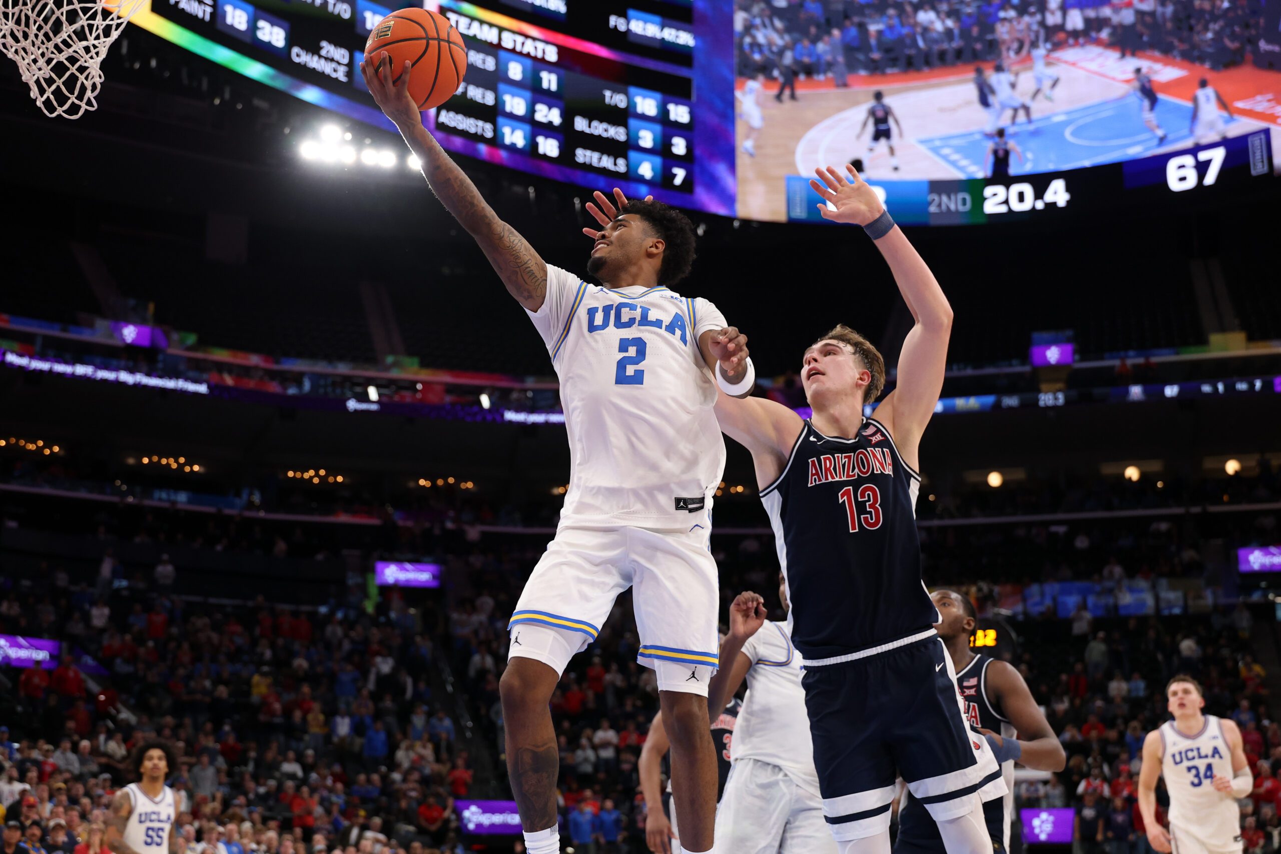 Nov 14, 2025; Inglewood, California, USA;  UCLA Bruins guard Donovan Dent (2) goes to the basket past Arizona Wildcats center Motiejus Krivas (13) during the second half of the Hall of Fame Series game at Intuit Dome. Mandatory Credit: Kiyoshi Mio-Imagn Images