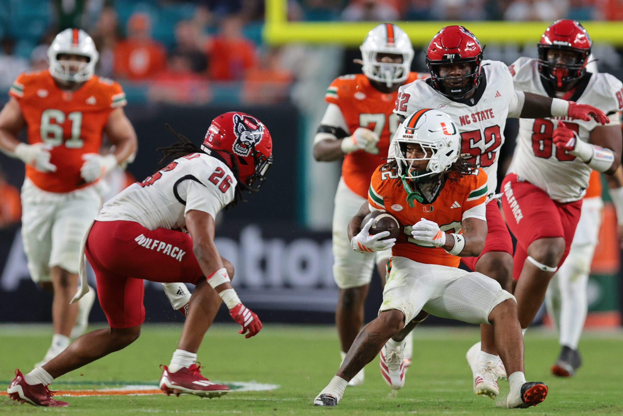 Nov 15, 2025; Miami Gardens, Florida, USA; Miami Hurricanes running back Girard Pringle Jr. (22) carries the football against NC State Wolfpack defensive back Asaad Brown Jr. (26) during the third quarter at Hard Rock Stadium. Mandatory Credit: Sam Navarro-Imagn Images