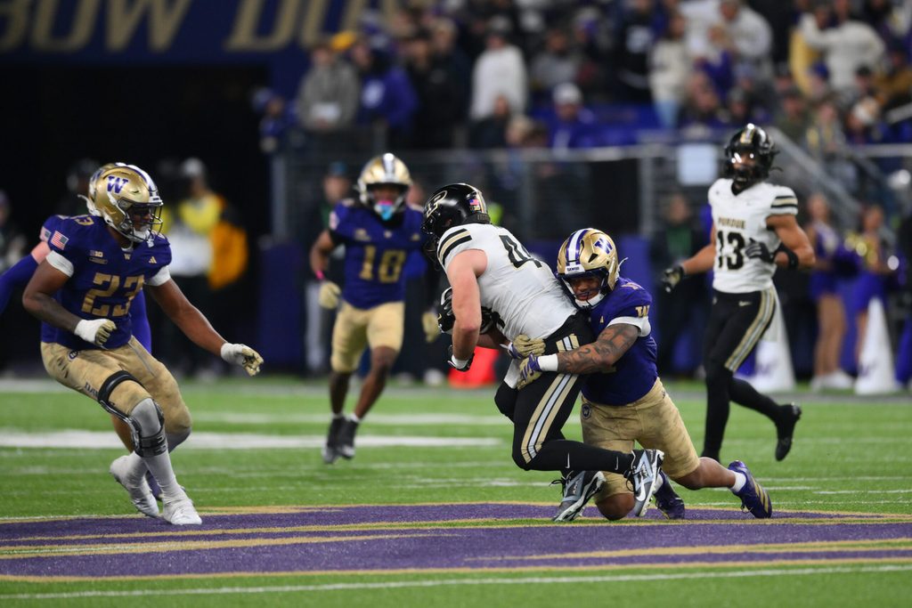 Nov 15, 2025; Seattle, Washington, USA; Washington Huskies linebacker Deven Bryant (17) tackles Purdue Boilermakers tight end Christian Moore (44) during the second half at Husky Stadium. Mandatory Credit: Steven Bisig-Imagn Images