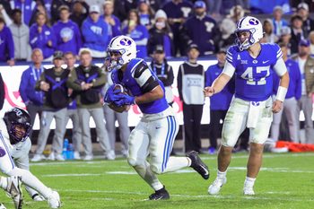 Nov 15, 2025; Provo, Utah, USA; BYU Cougars quarterback Bear Bachmeier (47) hands the ball off to running back LJ Martin (4) to score a touchdown against the Texas Christian University Horned Frogs during the fourth quarter at LaVell Edwards Stadium. Mandatory Credit: Rob Gray-Imagn Images