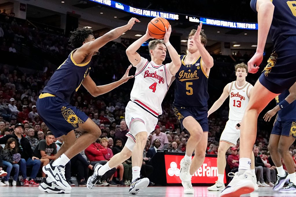 Ohio State Buckeyes guard Gabe Cupps (4) dribbles between Notre Dame Fighting Irish guard Jalen Haralson (10) and guard Cole Certa (5) during the men's NCAA basketball game at Value City Arena in Columbus on Nov. 16, 2025. Ohio State won 64-63.