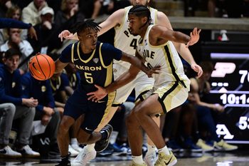 Nov 16, 2025; West Lafayette, Indiana, USA;  Akron Zips guard Tavari Johnson (5) drives past Purdue Boilermakers guard C.J. Cox (0) during the second half at Mackey Arena. Mandatory Credit: Marc Lebryk-Imagn Images