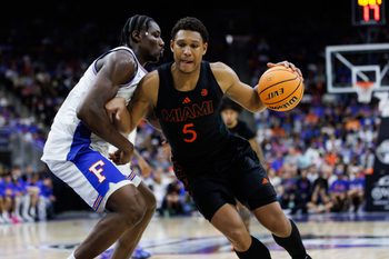 Nov 16, 2025; Jacksonville, Florida, USA; Miami Hurricanes forward Malik Reneau (5) drives to the basket at Florida Gators center Rueben Chinyelu (9) during the second half at VyStar Veterans Memorial Arena. Mandatory Credit: Matt Pendleton-Imagn Images