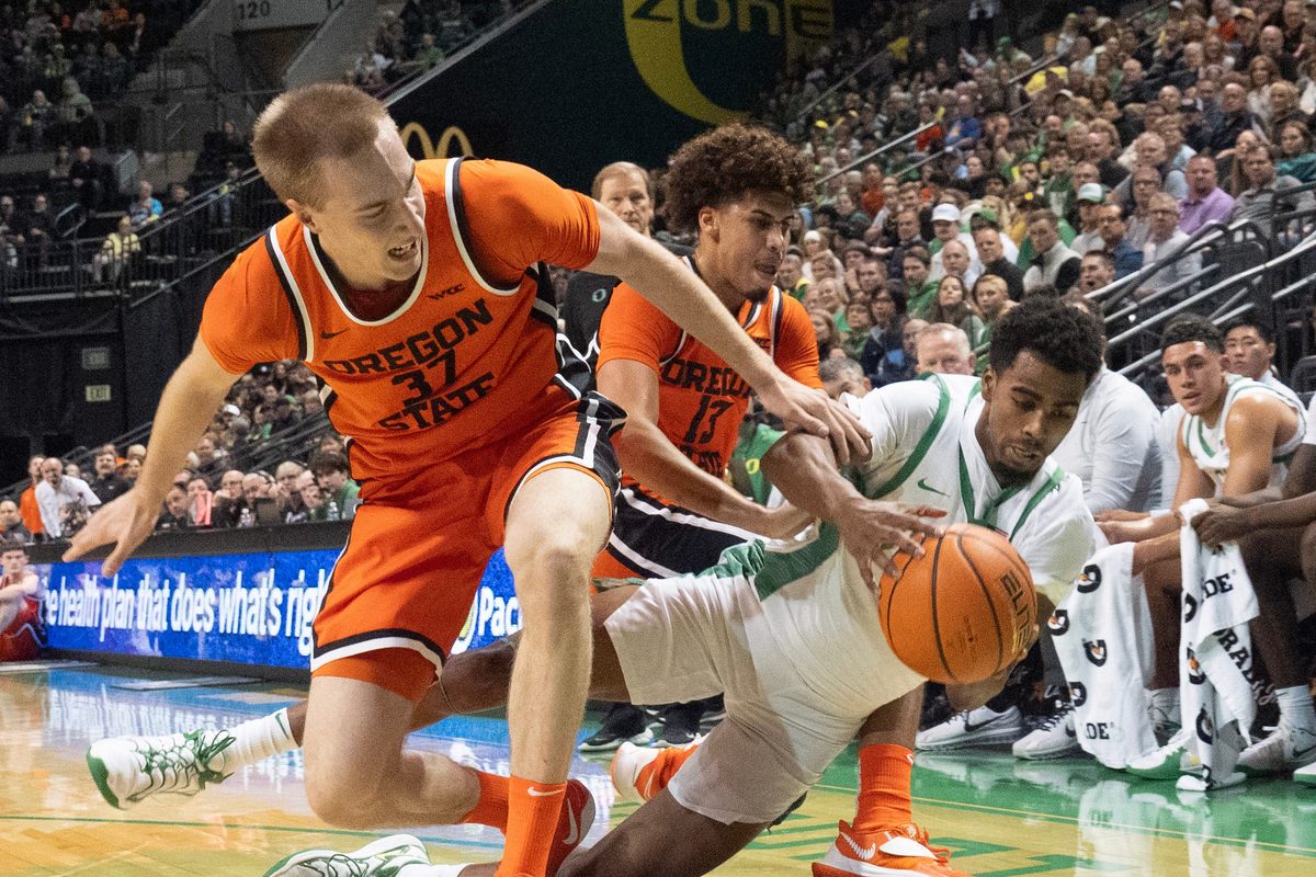 Oregon State’s Olavi Suutela, left, and Isaiah Sy battle Oregon’s Sean Stewart for a loose ball during the first half at Matthew Knight Arena in Eugene Nov. 17, 2025.