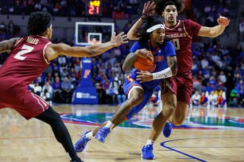 Nov 11, 2025; Gainesville, Florida, USA; Florida Gators guard Boogie Fland (0) dribbles the ball through Florida State Seminoles guard Lajae Jones (10) and guard Cam Miles (2) during the second half at Exactech Arena at the Stephen C. O'Connell Center. Mandatory Credit: Morgan Tencza-Imagn Images