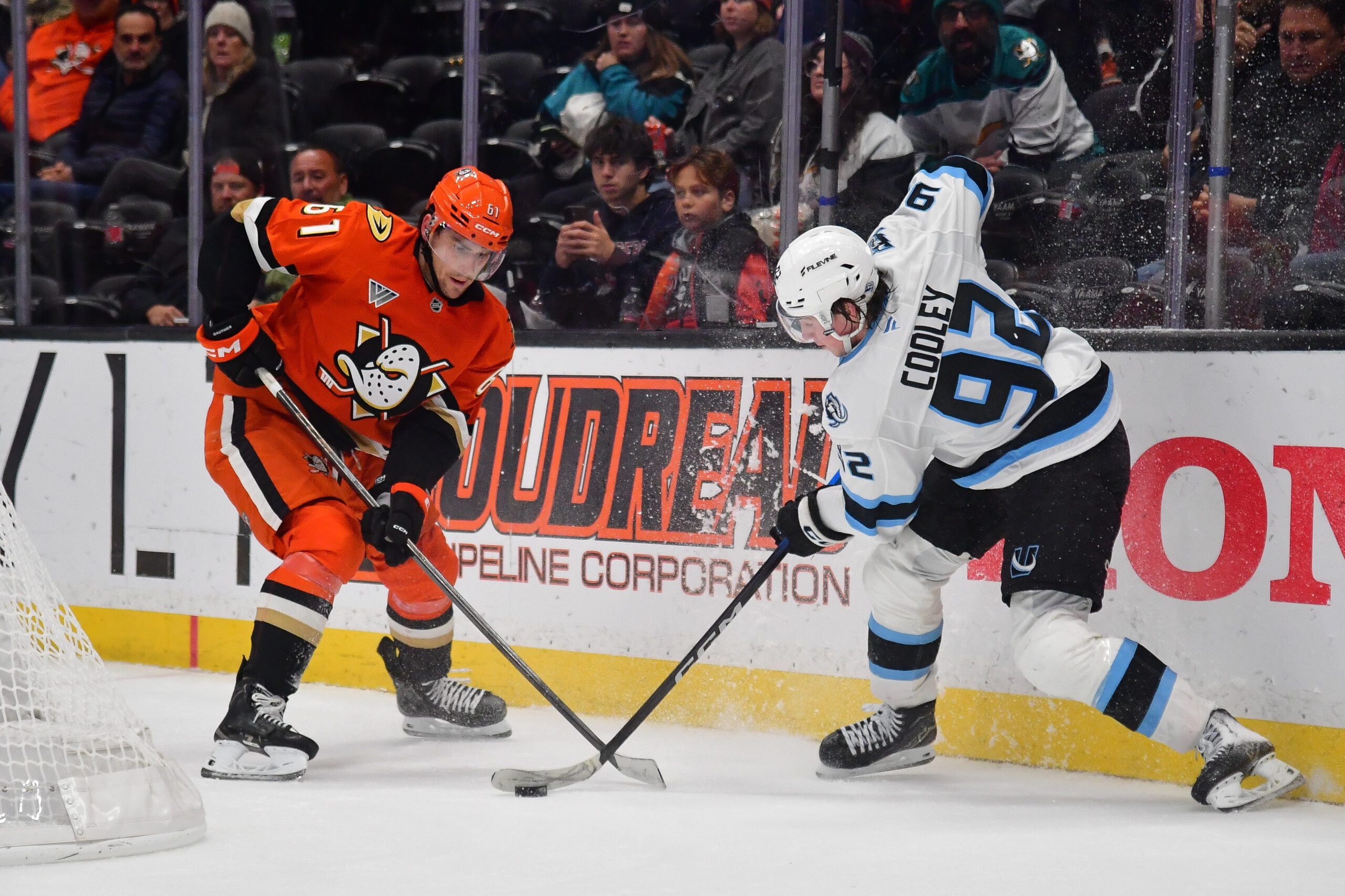 Nov 17, 2025; Anaheim, California, USA; Anaheim Ducks left wing Cutter Gauthier (61) and Utah Mammoth center Logan Cooley (92) play for the puck during the third period at Honda Center. Mandatory Credit: Gary A. Vasquez-Imagn Images